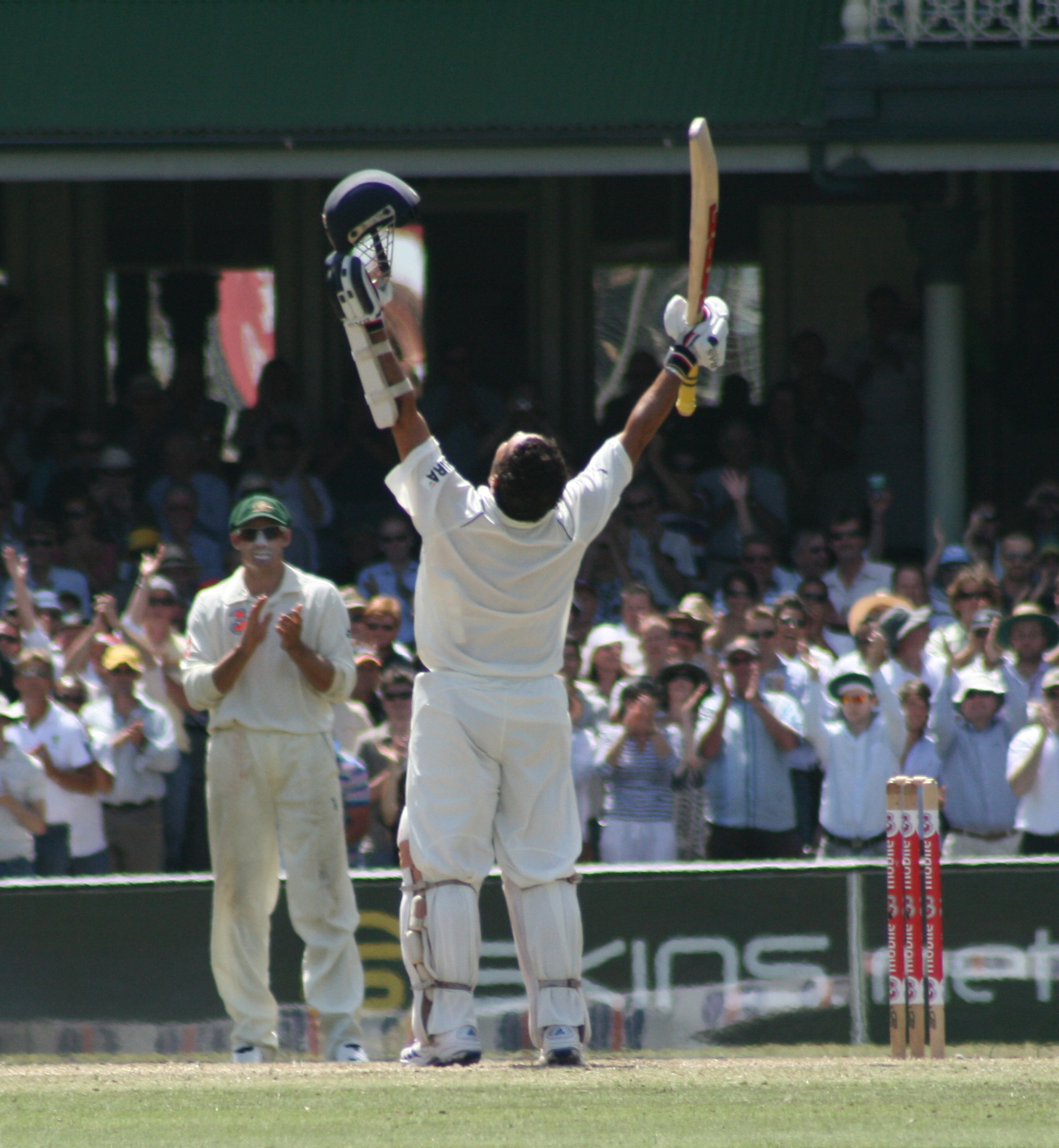 Sachin Tendulkar raises bat and helmet to the sky as the crowd erupts