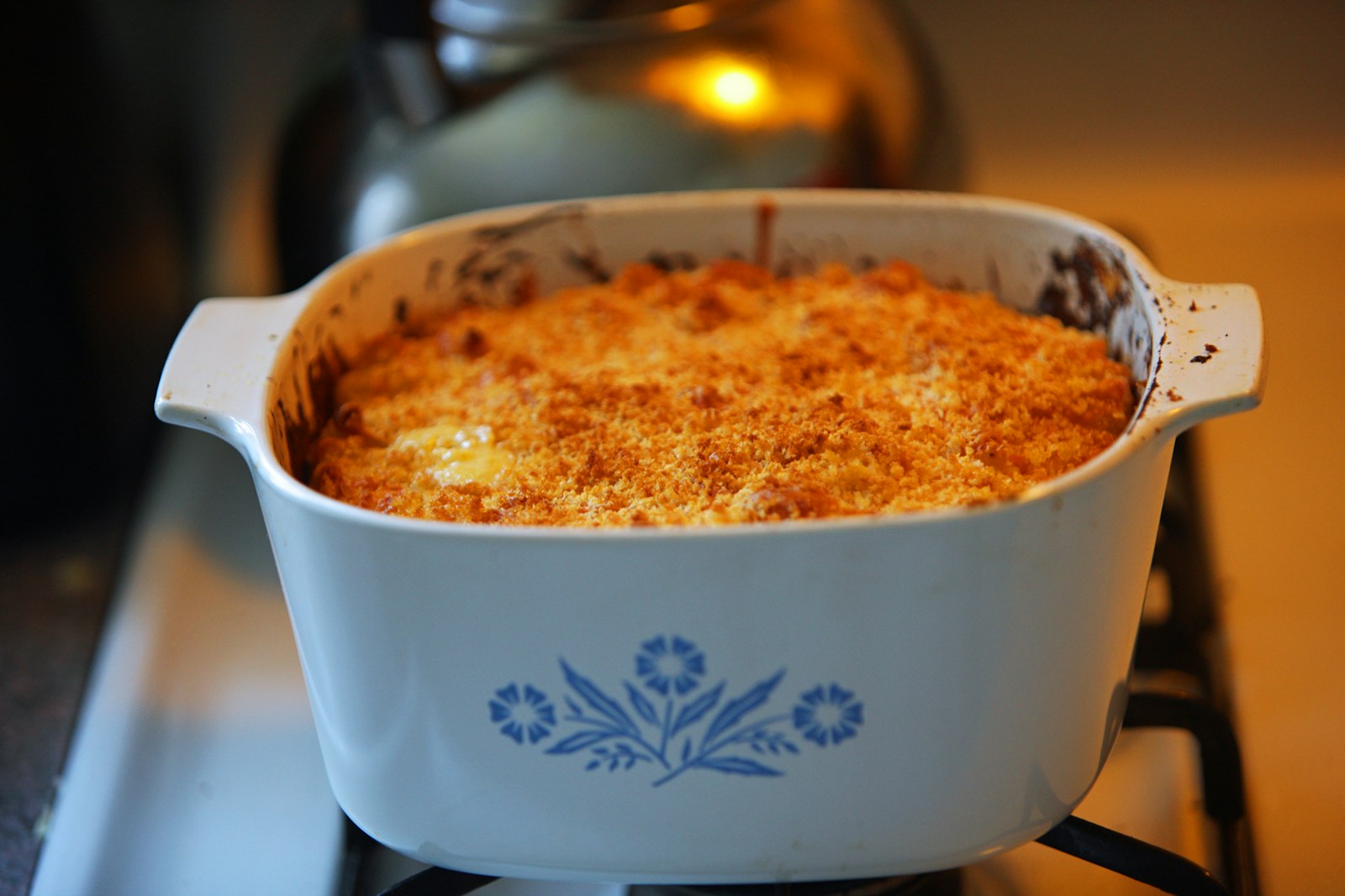 A cornflower CorningWare casserole dish with a golden crumb top