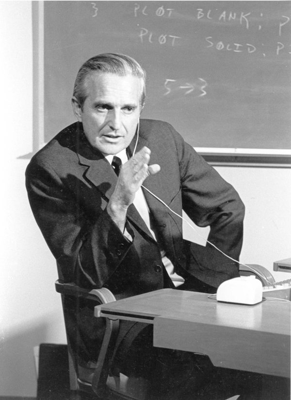 Douglas Engelbart at a desk with a keyboard and mouse, 1968