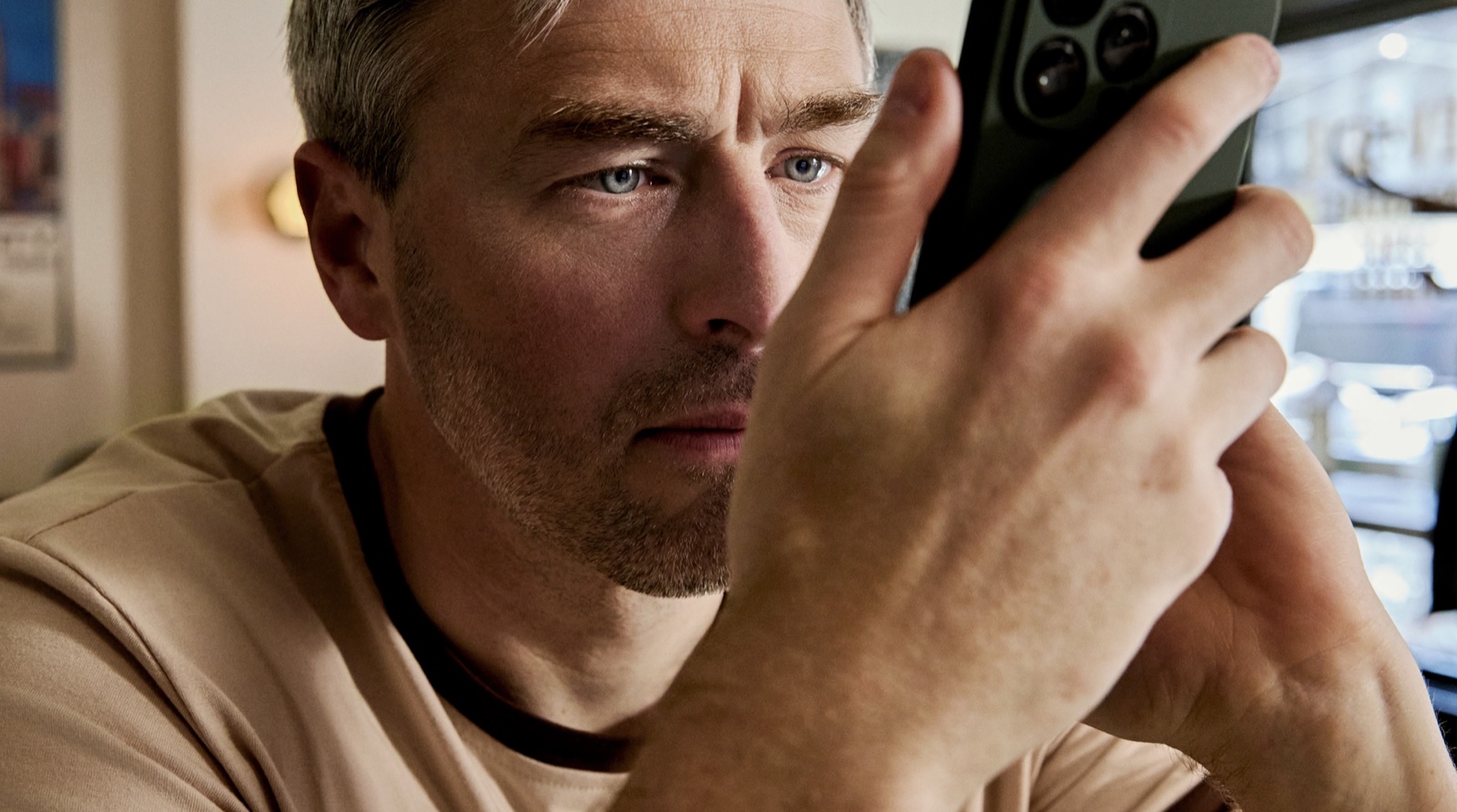 A close-up of Bradford Manning holding a phone directly against the side of his face, one eye almost touching the screen