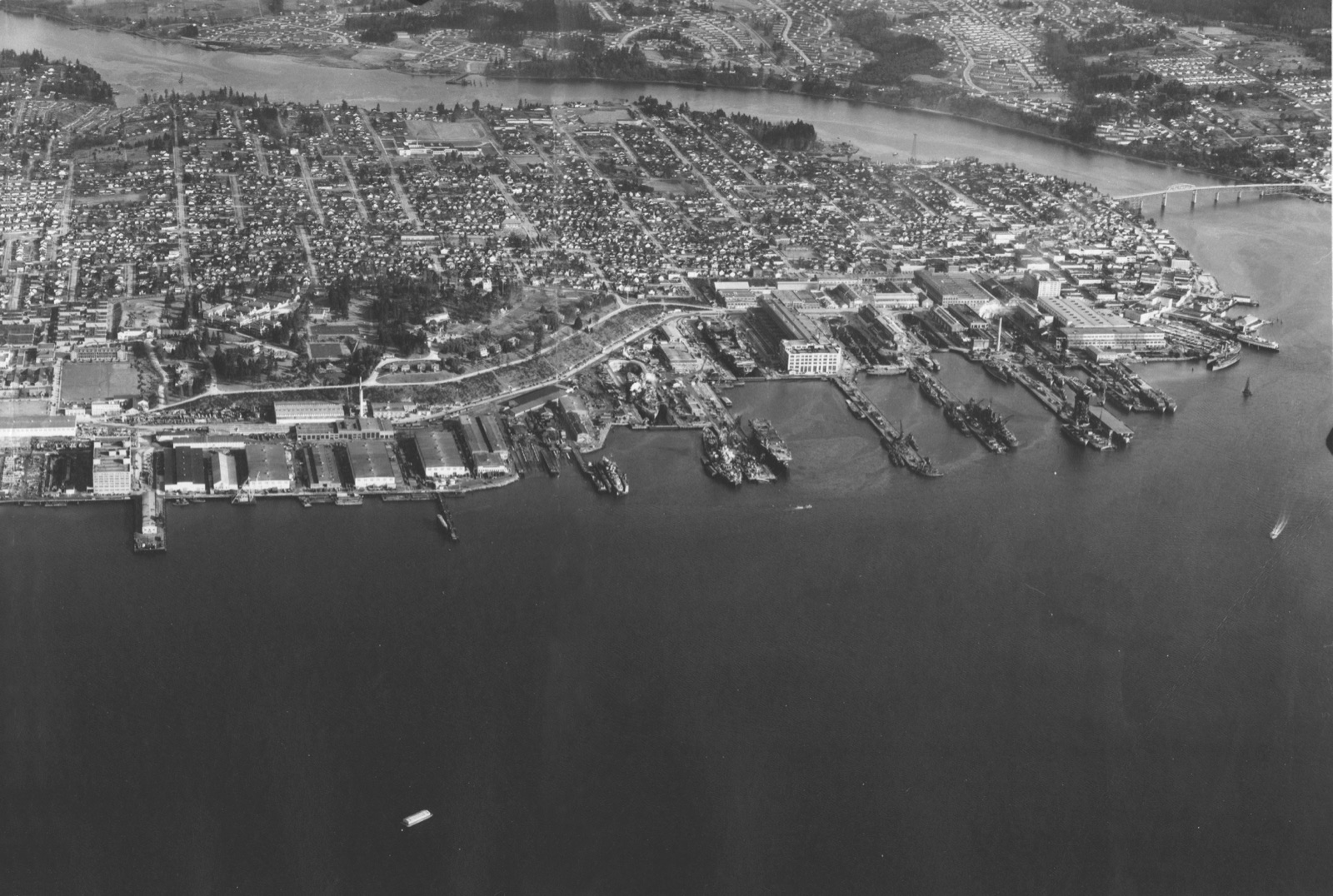 Aerial view of the Puget Sound Navy Yard and the town of Bremerton in 1945, warships in the docks