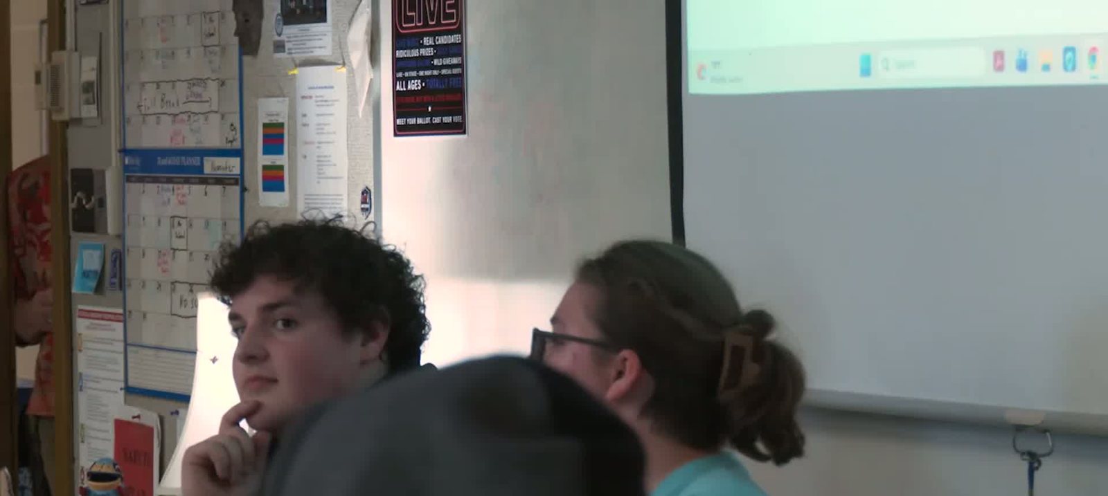 Alaric Martin, a high school senior with curly dark hair, sitting with his chin on his hand in a classroom.