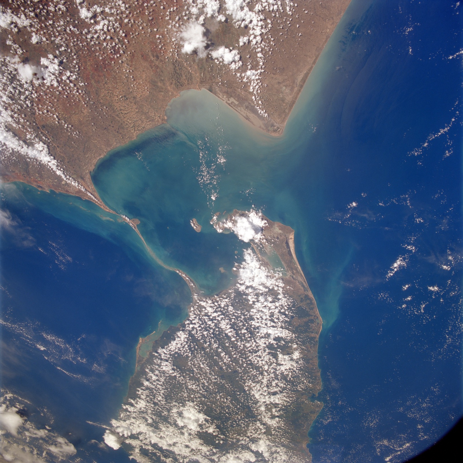 Satellite photograph of the sea between India and Sri Lanka, with India at the top left, Sri Lanka at the lower right, and a pale chain of shallows and sandbanks running between the two coasts