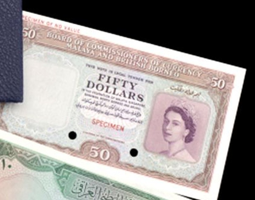 A pink and green fifty-dollar specimen note from the Board of Commissioners of Currency, Malaya and British Borneo, with a portrait of a young Queen Elizabeth II on the right. The words Specimen of no value run across the top corner, SPECIMEN is printed in red, and two holes are punched through it.