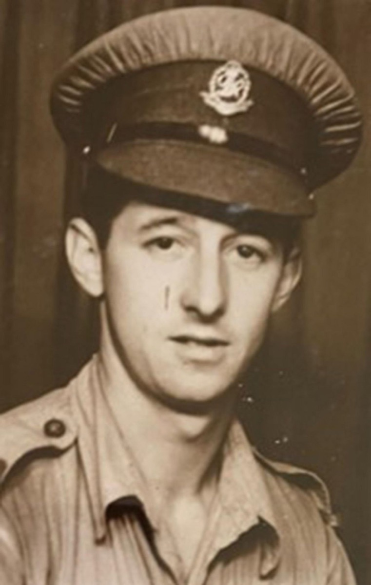 A black and white photo of a young Owen Filer in an army uniform and peaked cap with a cap badge.