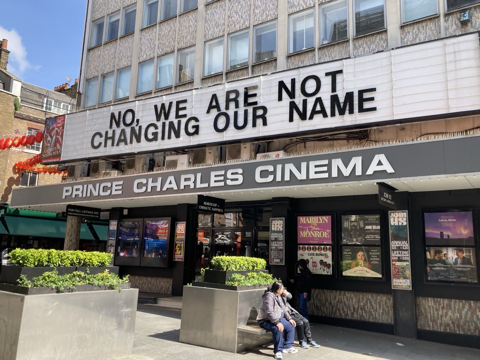 The Prince Charles Cinema in sunshine, with its letter board reading No, we are not changing our name.