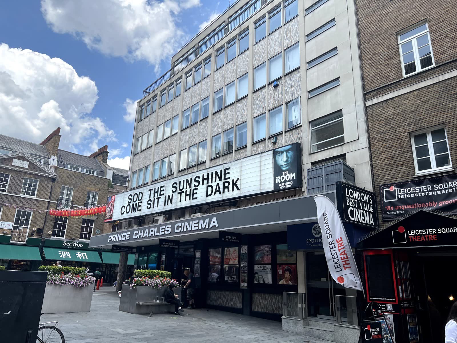 The cinema under a blue sky, with its letter board reading Sod the sunshine, come sit in the dark, and a poster for monthly screenings of The Room.