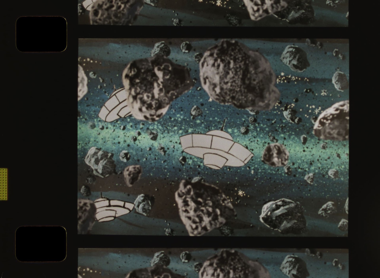 A strip of 16mm film with sprocket holes, its frames showing hand-drawn flying saucers moving through a dark asteroid field over a pale blue nebula